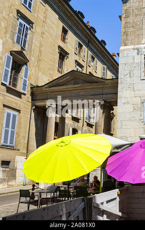 Geneva, Switzerland - July 19, 2019: Colorful umbrellas protecting people against sun in the outdoor garden of a restaurant. Yellow umbrella. Geneva historical center, old town street. Protection. Stock Photo