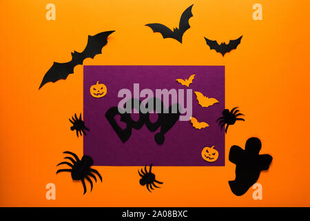 Halloween holiday concept top view. Pumpkins, ghost, spiders, bats on the orange background. Stock Photo