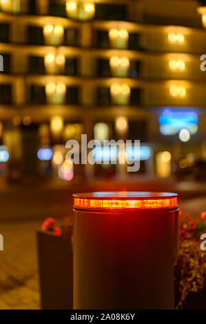 A retractable bollard with a red warning light as a barrier to a pedestrian area at night in Bansin, Germany. In the background you can see points of Stock Photo
