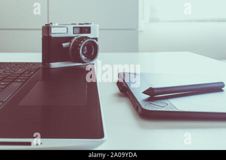 tablet drawing in workspace with laptop and vintage camera Stock Photo