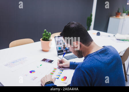 Man working on documents at desk in office Stock Photo