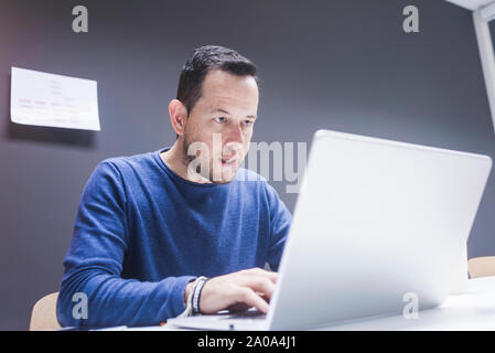 Bearded Man working on laptop in office Stock Photo