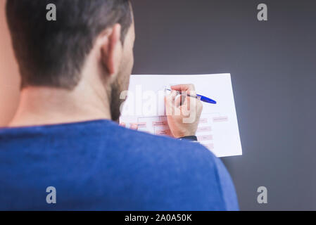 office worker writing notes on chart Stock Photo