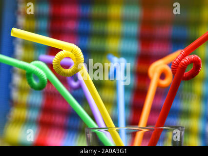 Colorful plastic straws in the glass cup. Stock Photo