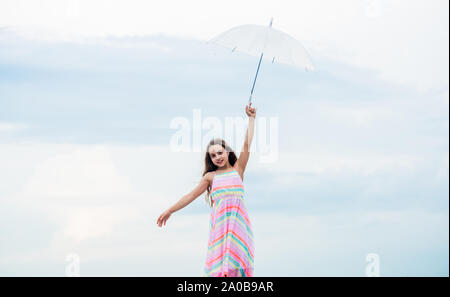 Fly drop parachute. Dreaming about first flight. Kid pretending fly. Happy childhood. I believe i can fly. Touch sky. Fairy tale character. Feeling light. Girl with light umbrella. Anti gravitation. Stock Photo