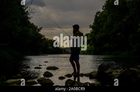 Good times. evening fishing. sport activity and hobby. summer weekend. fisherman show fishing technique use rod. experienced fisher wait for fish in water. man catching fish. mature man fly fishing. Stock Photo