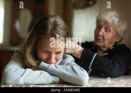 A crying little girl is comforted by her grandmother. Stock Photo
