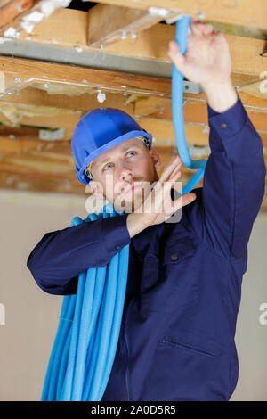 a plumber checking ceiling pipes Stock Photo