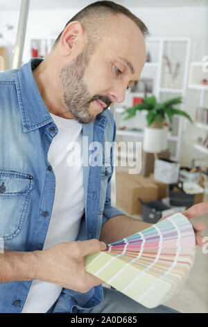 man choosing color from colour swatches book Stock Photo