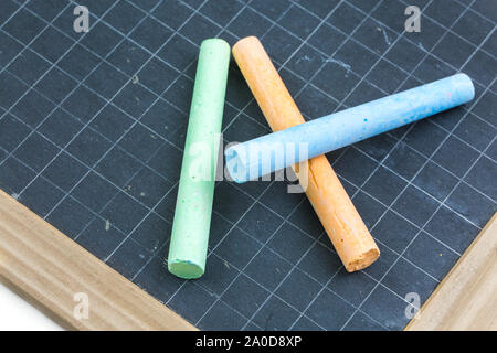 Closeup on colored chalk placed on a school slate Stock Photo