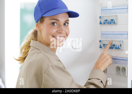 female worker inspecting fuse board Stock Photo