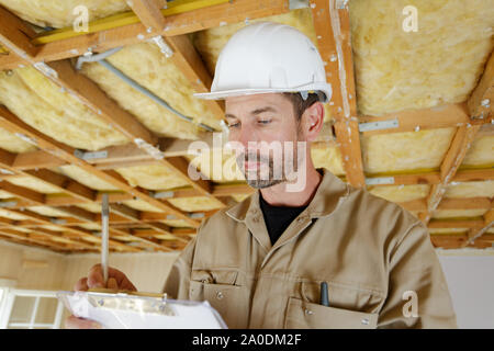 male builder making notes on a clipboard Stock Photo