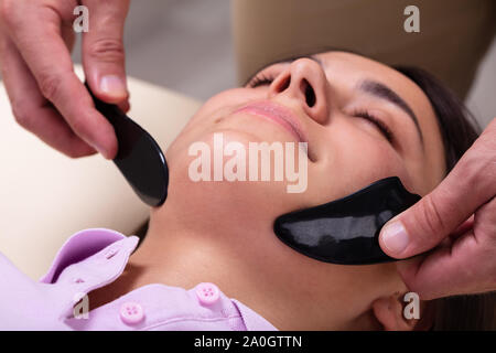 Beautiful Young Woman Have Face Gua Sha Massage Treatment At Asian Beauty Clinic Stock Photo