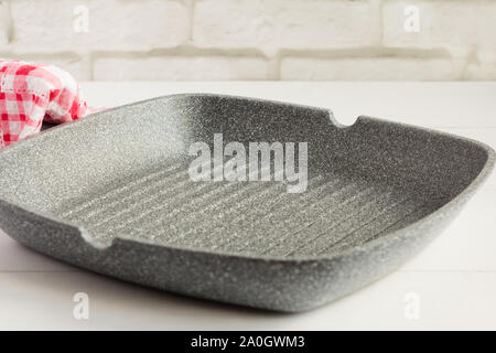 empty grill pan with non-stick coating on light background Stock Photo