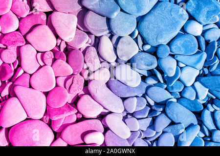 close-up of pile colorful pebbles from tropical sea beach, in trendy neon color. Stock Photo