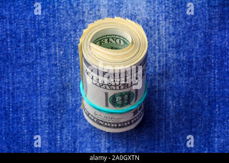 Roll of dollars on denim background, usa concept Stock Photo