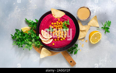 Tasty and healthy food concept Beetroot hummus in plate with chickpeas and pita bread top view Stock Photo