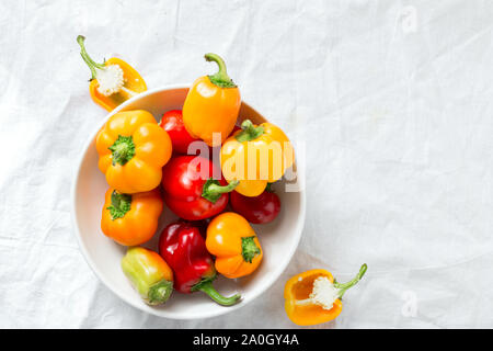 Yellow and red bell peppers in plate on white background top view Stock Photo