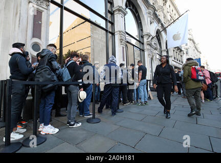 Customers queue to collect their pre-orders for new Apple products outside the tech giant's flagship store in Regent Street, central London. Stock Photo