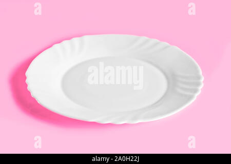 Empty white porcelain plate on a trendy pink background. Ready-made template for collage and design. Stock Photo