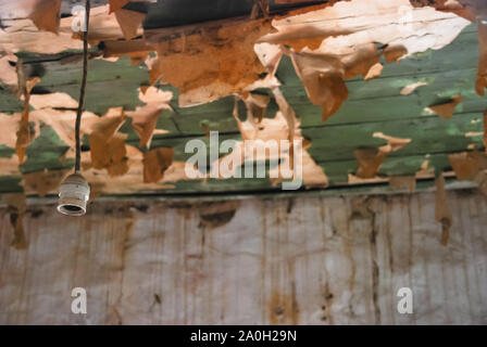 Close-up of paint peeling old wooden surface, background texture. Paint peels off wooden plank. Closeup. Stock Photo