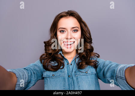 Self-portrait of nice cute stylish trendy flirty cheerful lovely attractive adorable brunette girl with wavy hair in casual denim shirt, showing tongu Stock Photo