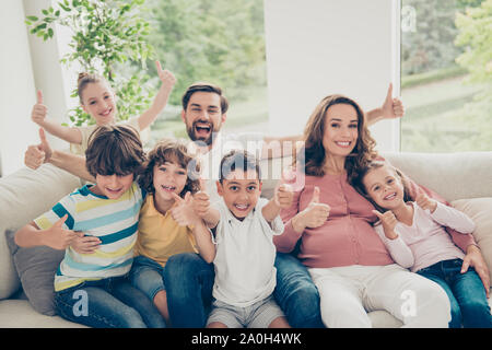 Free time concept. Close up photo nice, glad, positive, cheers large, full multiethnic family hispanic people demonstration or show thumb-up sit comfo Stock Photo