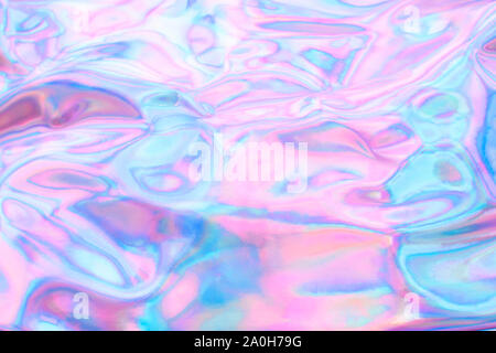 Holographic wrinkled abstract foil texture. Glittering blurred surface pack. Multicolor bright holographic foil background. Stock Photo