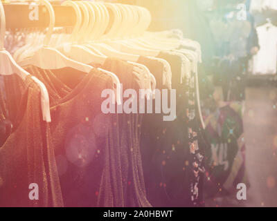 colored clothes on hangers, blurry, flare. Stock Photo