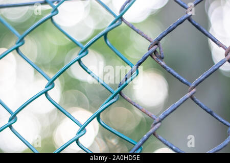 New Chain link next to an old chain link fence with a bokeh background Stock Photo
