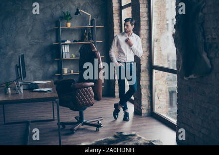 Full legs body size portrait of handsome attractive nice-looking man in formal wear stand near window and comfort chair in bright light interior Stock Photo