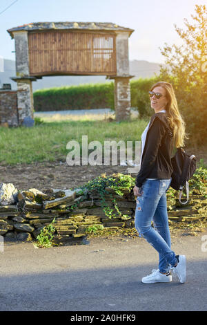 Young woman in front of a typical horreo in Galicia, Spain Stock Photo