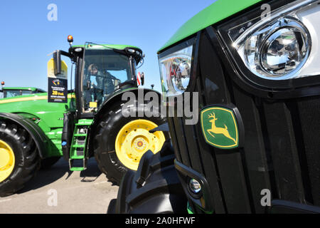 Kaunas, Lithuania - April 04: John Deere tractors and logo in Kaunas on April 04, 2019. John Deere is the American corporation that manufactures agric Stock Photo