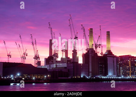 Building cranes and Battersea Power Station at dusk in silhouette Stock Photo