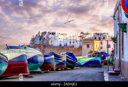 The old town of Essaouria surrounded by the wall of the fortress,in the foreground with famous blue wooden fishing boats. Stock Photo