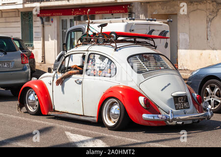 Nice, France - August 13, 2018: White red Volkswagen beetle is on a street with a driver inside
