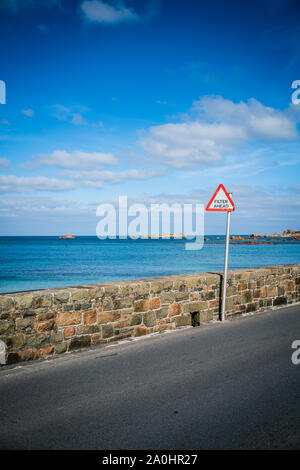 Filter in turn sign at the beautiful sun drenched Cobo Bay on the west coast of the island of Guernsey in the Channel Islands, UK. Stock Photo