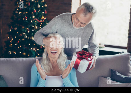 Cheerful glad amazed excited beautiful granny sitting on couch d Stock Photo