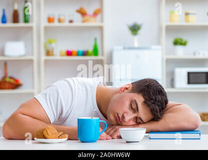 The man falling asleep during his breakfast after overtime work Stock Photo