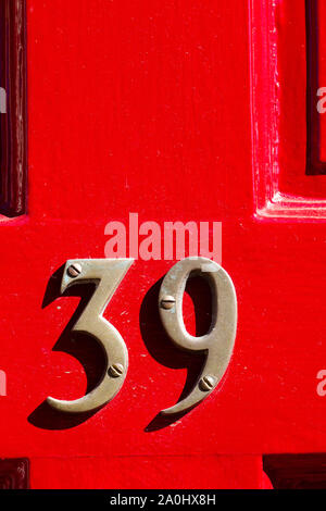 House number 39 on a bright red wooden front door Stock Photo