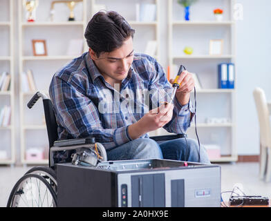 The computer repairman on wheelchair working Stock Photo