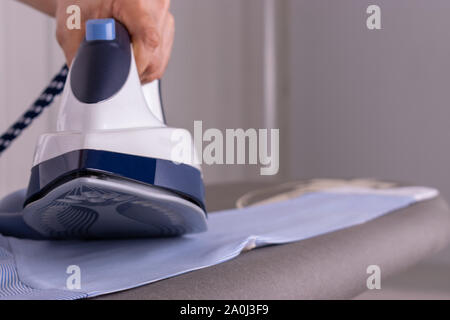 Man With Laptop While Ironing Cloth Stock Photo - Download Image