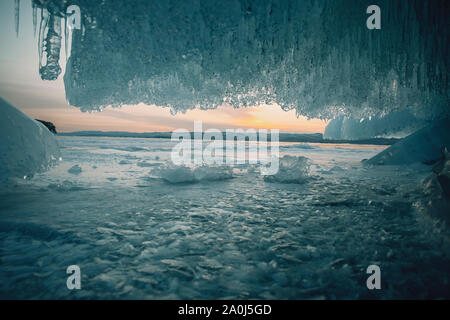 Ice cave and cracks in baikal lake at sunset Stock Photo