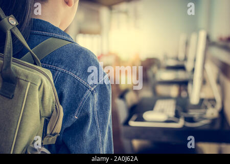 Girl with backpack entering to computer classroom. Education concept. Stock Photo