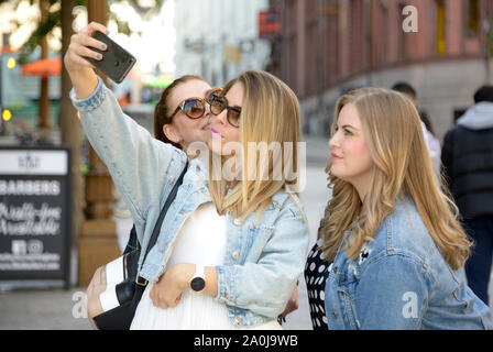 Three ladies, taking selfies, while on holiday in Nottingham. Stock Photo