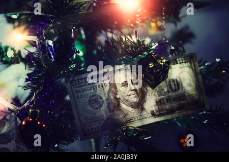 Hundred dollar bills. Money on Christmas tree. Small decorated Christmas tree on a blue background Stock Photo