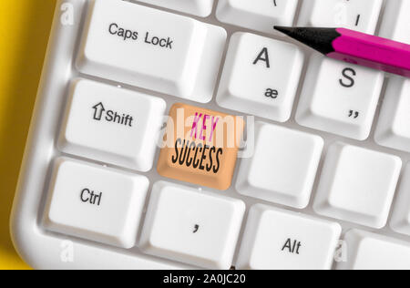 Conceptual hand writing showing Key Success. Concept meaning generally three to five areas that company may focus on White pc keyboard with note paper Stock Photo