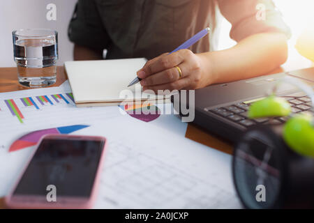 Woman is writing on working desk in office. Business concept. Stock Photo