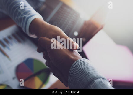 Two colleagues shaking hands together celebrating finished work. Business concept. Stock Photo