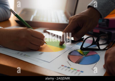 Two colleagues discussing and planing together with trade data chart document on office desk. Business and Office life concept. Stock Photo